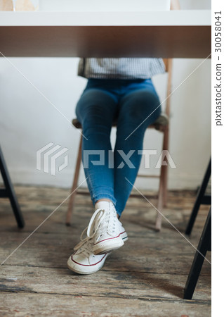 Close up of female legs with shoes under table Close up of female legs with shoes under table 30058041