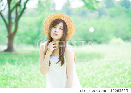 A woman wearing a straw hat A woman wearing a straw hat 30063855