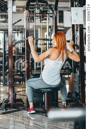 Woman training her back and shoulder with in a gym 30066714