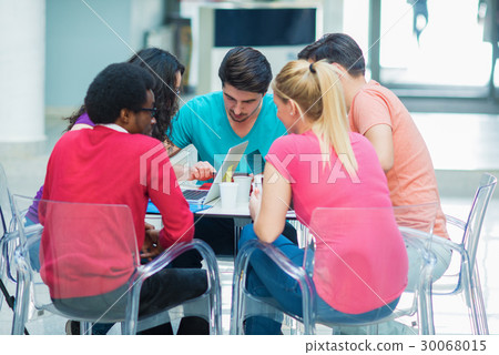 A group of teenagers sitting at the table in cafe A group of teenagers sitting at the table in cafe 30068015