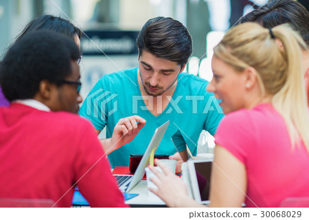A group of teenagers sitting at the table in cafe A group of teenagers sitting at the table in cafe 30068029