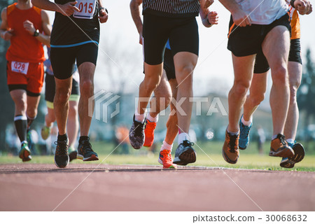 Group of marathon racers runningon the track Group of marathon racers runningon the track 30068632