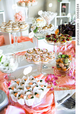Table with delicious sweets covered with pink silk Table with delicious sweets covered with pink silk 30068844