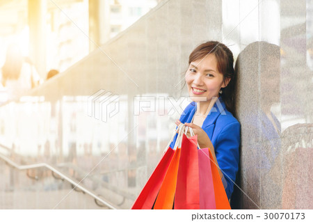 Youung woman carrying shopping bags at street 30070173
