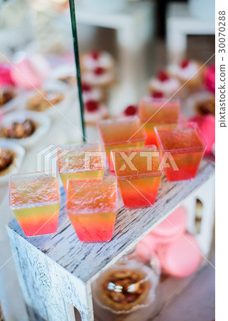 Pretty colorful jellies served in square glasses Pretty colorful jellies served in square glasses 30070288