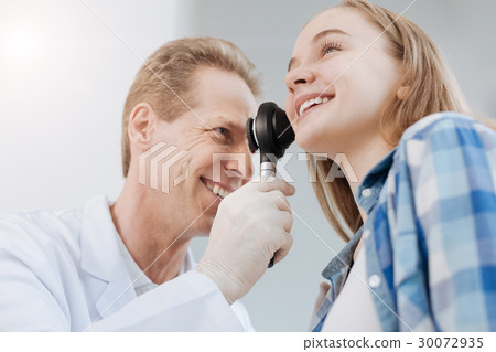 Smiling doctor using dermatoscope during 30072935