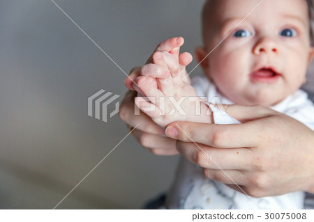 Newborn child claps with his mother's hands 30075008