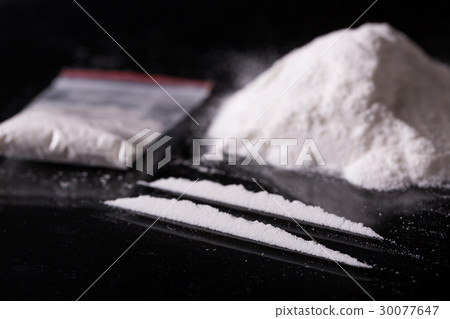Two lines and pile of cocaine on black background Two lines and pile of cocaine on black background 30077647