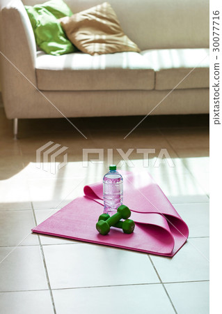 Fitness tools with mineral water on yoga mat 30077716