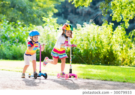 Kids riding scooter in summer park. 30079933