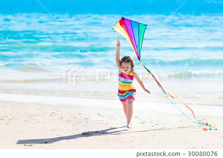 Child flying kite on tropical beach 30080076