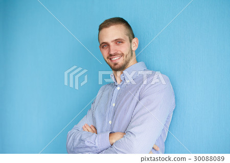 Man leaning against a blue wall 30088089