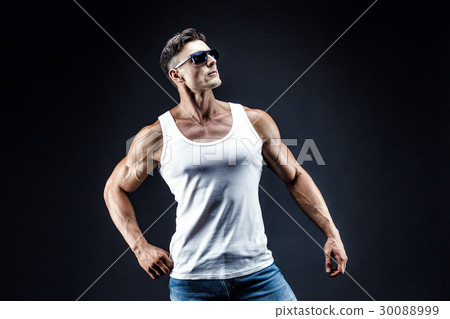 Handsome muscular man in dark glasses and a white Handsome muscular man in dark glasses and a white 30088999