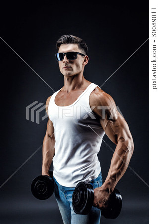 Handsome muscular man in dark glasses and a white Handsome muscular man in dark glasses and a white 30089011