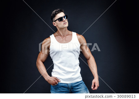Handsome muscular man in dark glasses and a white Handsome muscular man in dark glasses and a white 30089013