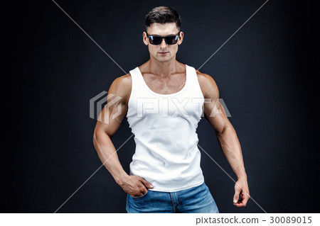 Handsome muscular man in dark glasses and a white Handsome muscular man in dark glasses and a white 30089015