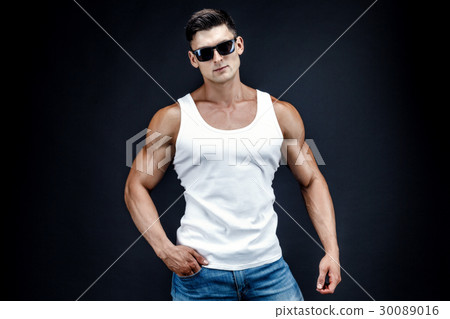 Handsome muscular man in dark glasses and a white Handsome muscular man in dark glasses and a white 30089016