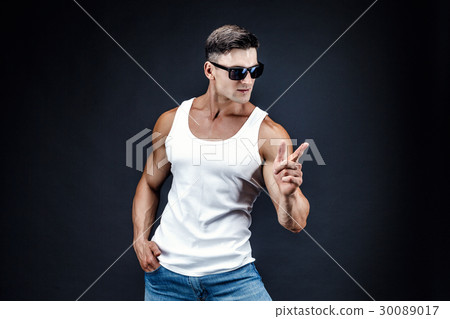 Handsome muscular man in dark glasses and a white Handsome muscular man in dark glasses and a white 30089017