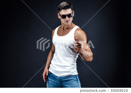 Handsome muscular man in dark glasses and a white Handsome muscular man in dark glasses and a white 30089028