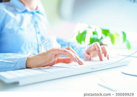 Woman office worker typing on the keyboard 30089929