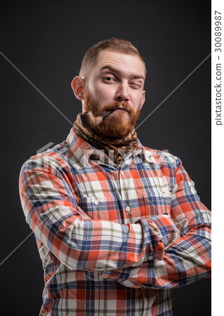 Portrait of bearded man smoking pipe with squinted 30089987
