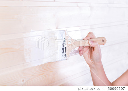 Woman painting wooden boards in white color 30090207