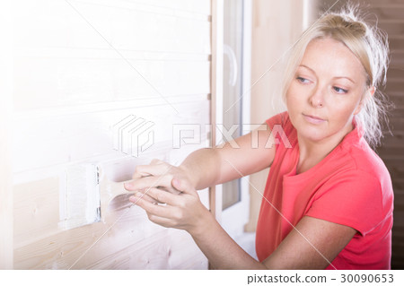 Woman painting wooden boards in white color Woman painting wooden boards in white color 30090653