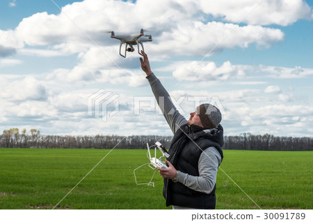 man holding of flying drone quadrocopter at the 30091789
