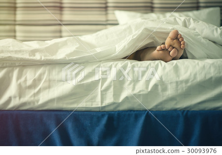 Female legs under blanket at sunset.  30093976