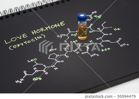 Close-up blue cap sample vial on black notebook 30094479