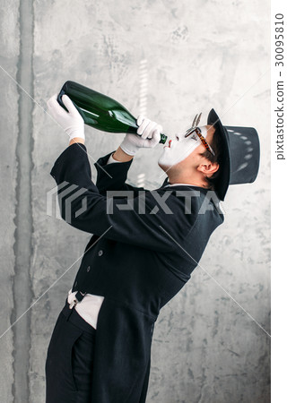 Mime actor drinking from a big bottle Mime actor drinking from a big bottle 30095810