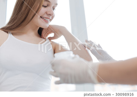 Caring medical specialist applying cream on 30098916