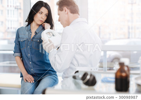 Qualified dermatologist using medical loupe for Qualified dermatologist using medical loupe for 30098987
