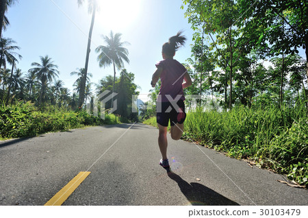 woman runner running at tropical forest trail 30103479