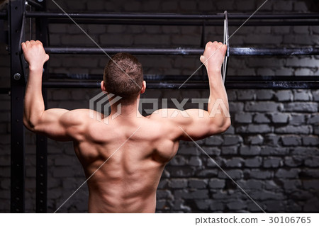 Rear view photo of muscular male doing exercises 30106765