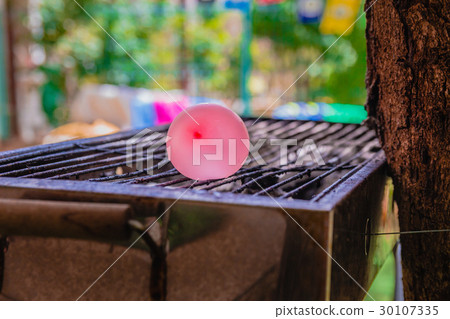 Balloon filled with water placed on a hot grill Balloon filled with water placed on a hot grill 30107335