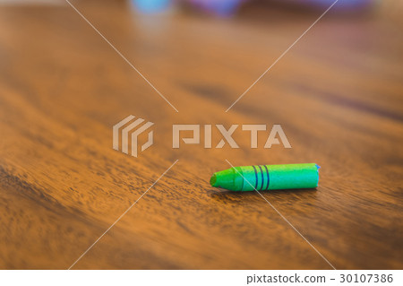 Green color pastel crayon on brown wooden table Green color pastel crayon on brown wooden table 30107386