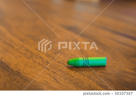 Green color pastel crayon on brown wooden table Green color pastel crayon on brown wooden table 30107387