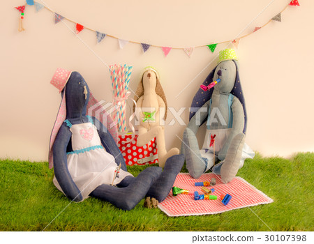 Handmade cloth rabbit dolls sitting on the grass  30107398