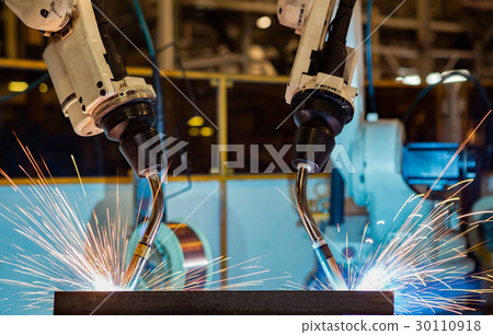 Close-up robots are welding in a car factory Close-up robots are welding in a car factory 30110918