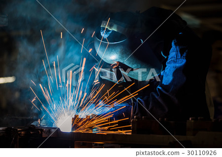 Worker is welding steel part in factory 30110926