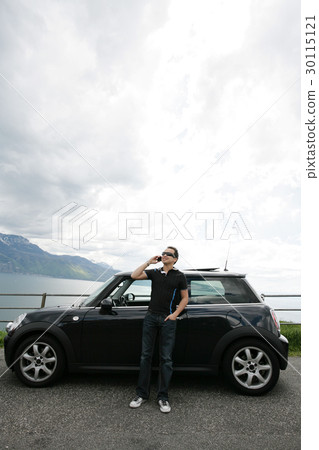 man talking happy out of his car in the hills 30115121