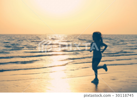 Woman Running on the Beach and Sunset. Photo Blur. 30118745