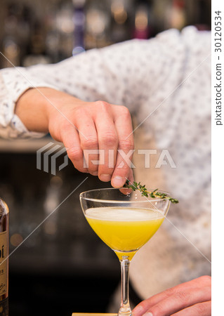 Barman putting lemon peel to prepare coctail Barman putting lemon peel to prepare coctail 30120534