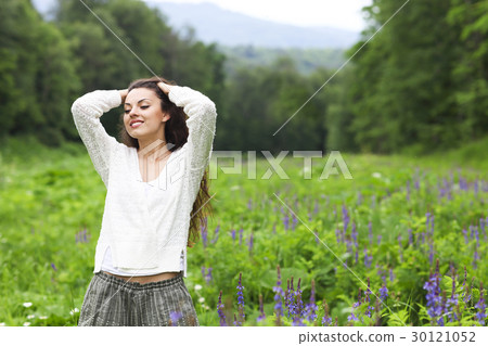 Happy pretty brunette woman in flower field Happy pretty brunette woman in flower field 30121052