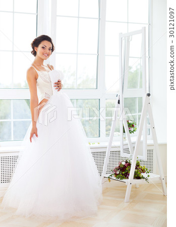 Beautiful bride-to-be trying her dress in shop 30121097