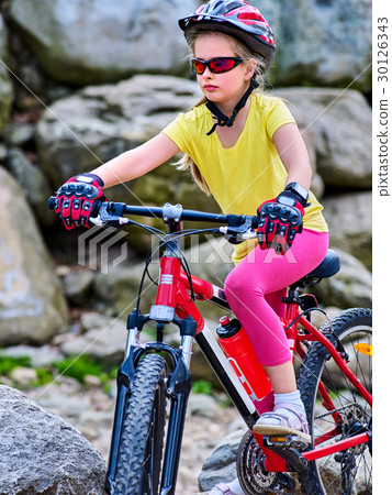 Child on bicycle ride mountain. Girl traveling in 30126343