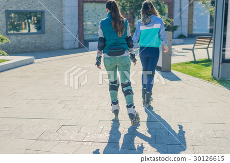 Two girls rollers go one after another Two girls rollers go one after another 30126615