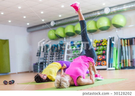 Fit athletic female doing single leg bridge 30128202