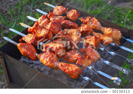 Grilled meat outdoors on metal skewers 30130313